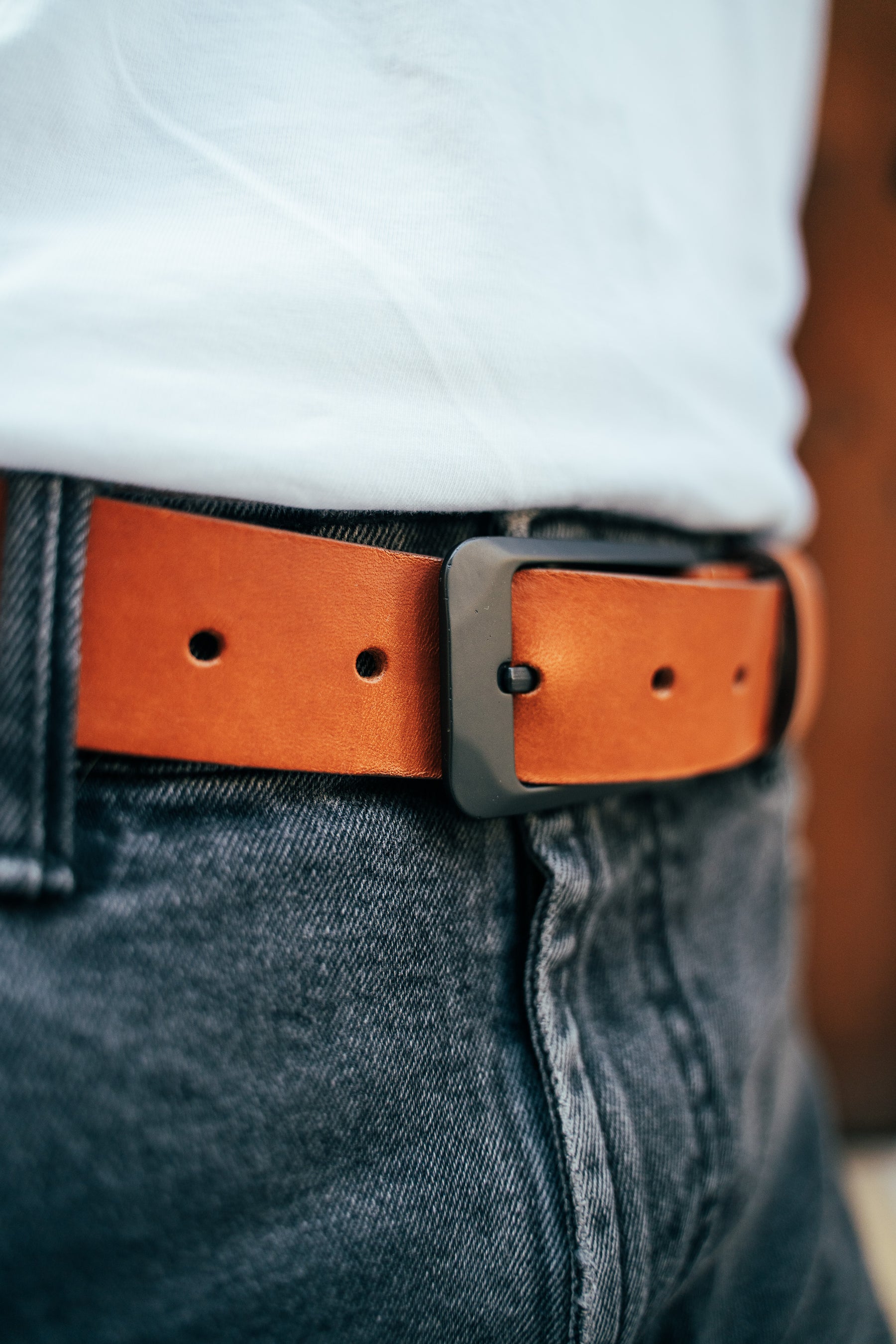 Zoom de la ceinture Modèle BOD en cuir lisse cognac portée par un homme